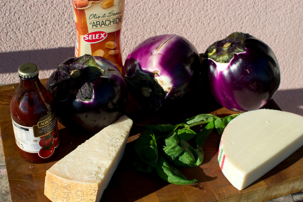 Ingredients glamour shot. 3 Eggplants. Parmigiana on the left and caciocavallo on the right. Peanut oil in back. These are not the correct portions for each item.